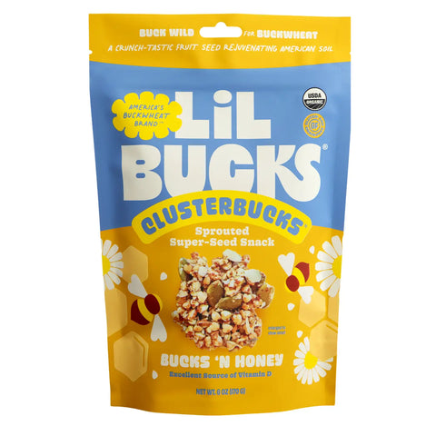 A 2 oz stand-up pouch of Lil Bucks ClusterBucks Sprouted Super-Seed Snack in Bucks 'N Honey flavor. The packaging features a bright blue top half and a yellow bottom half with white daisy illustrations, a honeybee graphic, and a photo of the snack mix in the center.